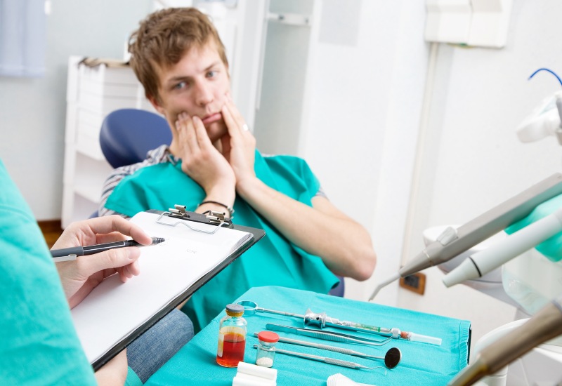 A patient in pain consulting for emergency dental care at Emergency Dentistry in St. Louis, MO